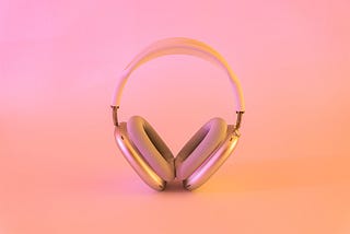 Headphones standing in front of a pink background.