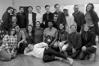 A group photo of 19 workshop participants in a training room