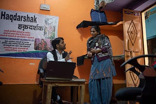 A Haqdarshak team member explains government welfare benefits to an Indian citizen