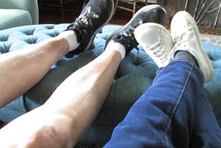 Two pairs of worn shoes resting side by side, suggesting a long-term relationship and shared life.