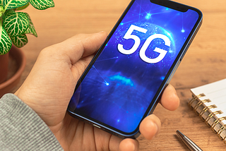 Image of a hand holding a Refurbished iPhone Compatible with 5G Networks.