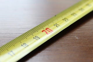 Photo of a yellow measuring tape with black numbers ranging from 17 to 25 and red number 20