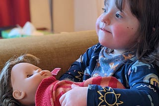 Young girl sitting holding doll