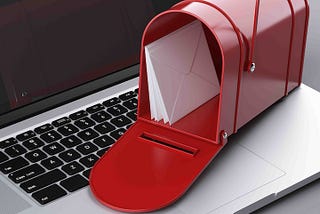 Red letter mailbox on top of a laptop computer