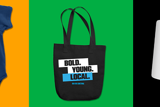 A graphic showcasing three pieces of Run for Something merch on bright color backgrounds. On the left is a navy blue baby onesie with a white “Future Candidate” megaphone design on an orange background. In the center is a black “Bold. Young. Local.” tote bag with blue and white lettering on a green background. On the right is a white mug with colorful “Run. Win. Repeat.” circles on a black background. The layout highlights the new merch collection available for purchase.
