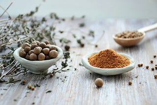 medicinal herbs in small bowls and dried leaves on a wooden table