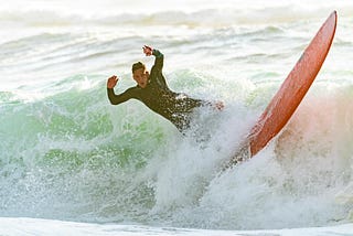 Image of a man falling off a surf board