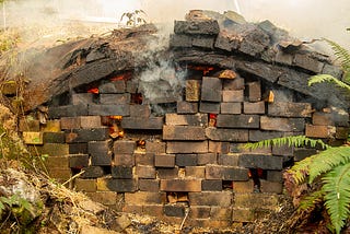 A brick kiln with smoke seeping out of it.