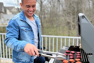 Gic grilling burgers and chicken sausages on his patio