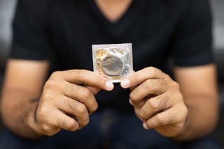 Close up Male hand holding Condom.