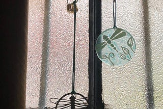 Wedding rings hanging together on dragonfly ornament