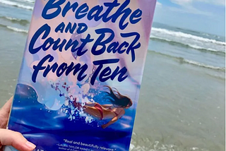 The book “Breathe and Count Back from Ten,” which shows a girl swimming, against the background of the ocean.