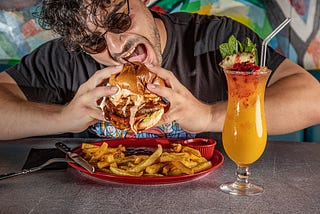 Man eating burger and fries.