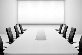 board room with a long white table and black leather chairs