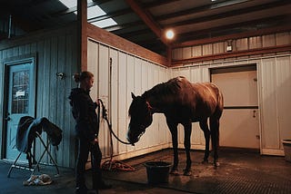 Woman getting her horse ready to ride