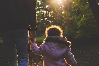 Father and kid walking holding hands