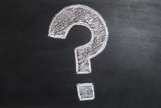 A question mark drawn on blackboard with white chalk