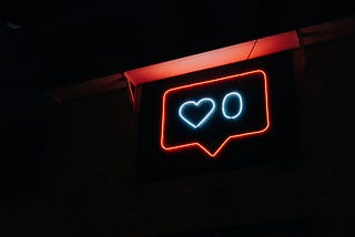 A light-up sign of an Instagram image with zero “likes.”