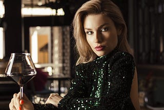 Attractive woman staring seductively while holding a glass of wine.
