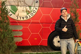 The author beside the bus for the Tajikistan national soccer team.