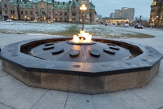 The Canadian Centennial Flame granite monument on Parliament Hill. It’s an ongoing fire using bio-gas, first lit in 1967, that doesn’t extinguish in the winter. The year that the province or territory joined Canada is carved into the granite in front of the shield. Photo Credit — Roxanne Joseph