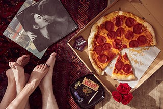 couple eating pizza, smoking a joint and listening to John Lennon