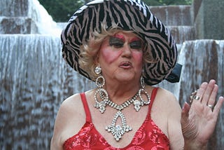 Drag queen Darcelle XV in red dress, costume jewels, and zebra striped hat at Portland’s Keller Fountain, circa 2012
