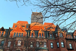 Brownstone buildings and a high-rise at sunset