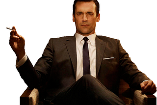 Don Draper sitting in a chair, looking right at the camera. His right elbow is resting on the chair arm and his hand is raised and he is holding a cigarette. He is dressed in a suit. He is taking up the whole space and exudes confidence