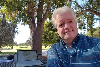 Don Simkovich sitting in front of laptop outdoors.