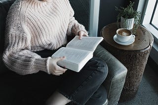 woman sitting on a couch with a book