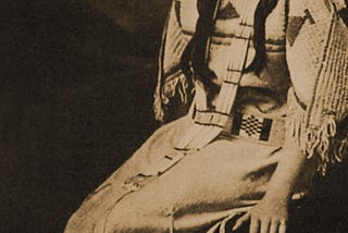 Photo of Oceti Sakowin Oyate woman in traditional dress on the cover of the novel Waterlilly, written by indigenous Dakota author Ella C. Deloria. Books like these written by survivors of board schools assimilation policy hold important cultural wisdom for tribal members and others.