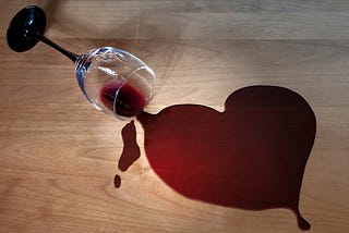 Spilled red wine into the shape of a heart