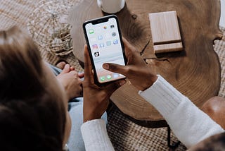 Two friends look at an iPhone together.