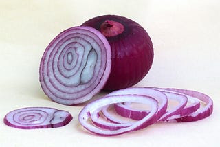 Photo of sliced raw red onions.