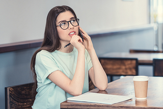 a writer thinking in a coffee shop