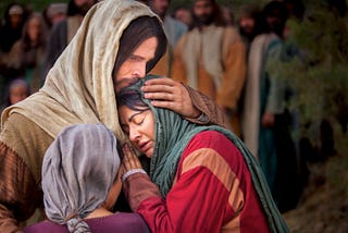 Christ comforts Mary and Martha with outstretched arms.