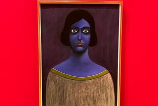 Painting of a blue-skinned woman with a dour expression on a bright wall