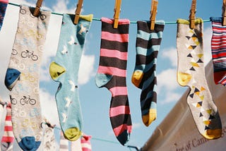 various patterned socks hanging on clothesline against blue sky