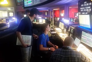 Interns looking at screens in mission control.
