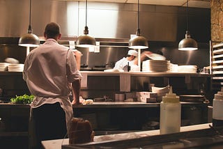 Un equipo trabaja en platillos en la línea de producción de la cocina de un restaurante.