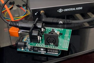 The Arduino UNO with the midi shield attached on top and USB and MIDI cables connected.