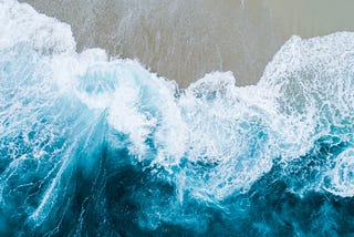 Aerial view of waves lapping a shore.