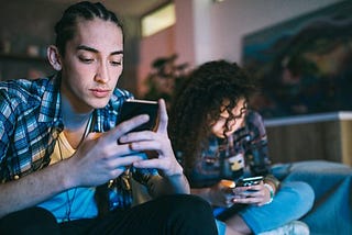 A girl and boy texting on their phones