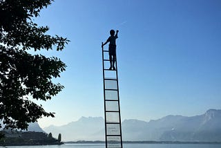 A ladder shoots up from a lake to the sky, a boy in silhouette climbs to the top