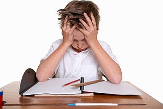 frustrated child with hands on head trying to do homework