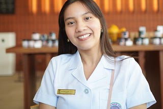 A woman wearing a collared shirt with a name tag.