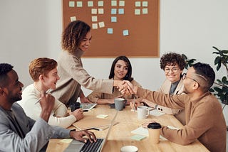 A group of people around a table working together.