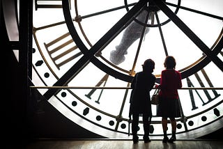 Two people looking at a large clock