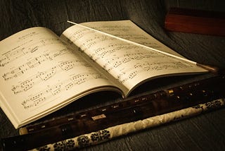 A conductor’s baton lying on an open musical score